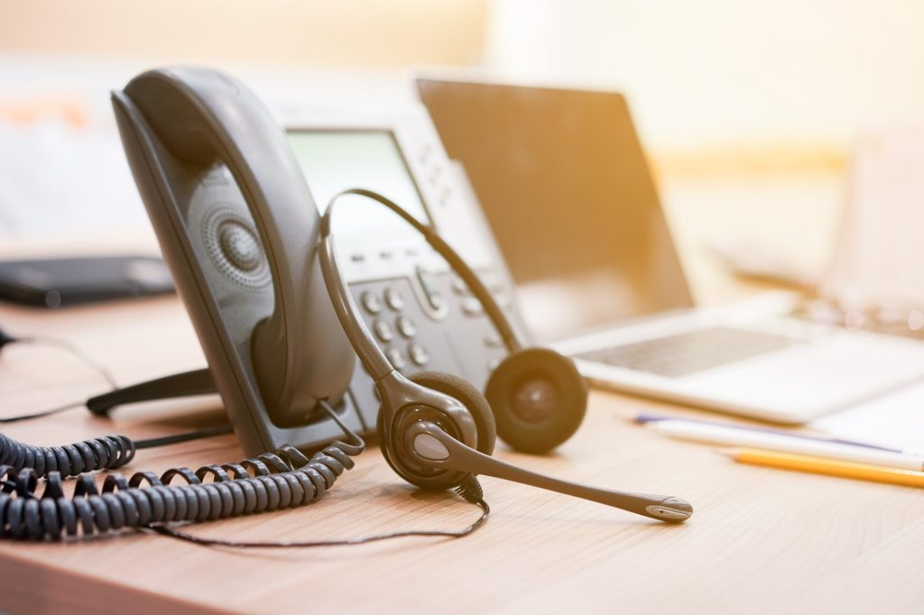 close up soft focus on headset with telephone devices at office desk for customer service support